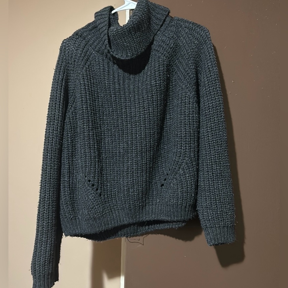 It’s a dark grey turtleneck long sleeve sweater